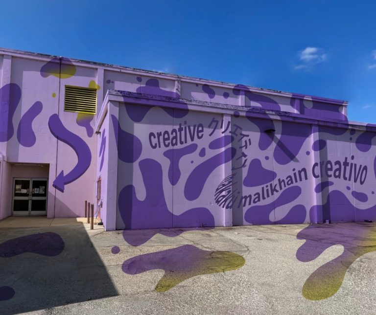 image of a purple building with the words creative in different languages. there are blob motifs in a darker purple 